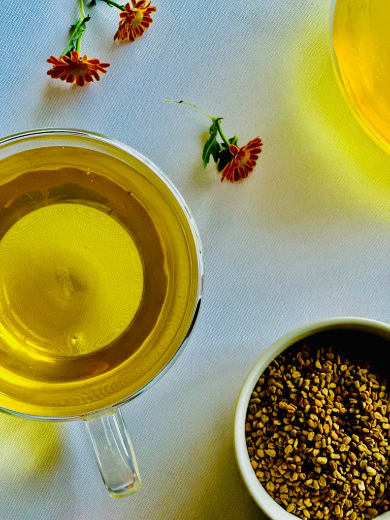 A freshly prepared teapot and cup of warm fenugreek tea