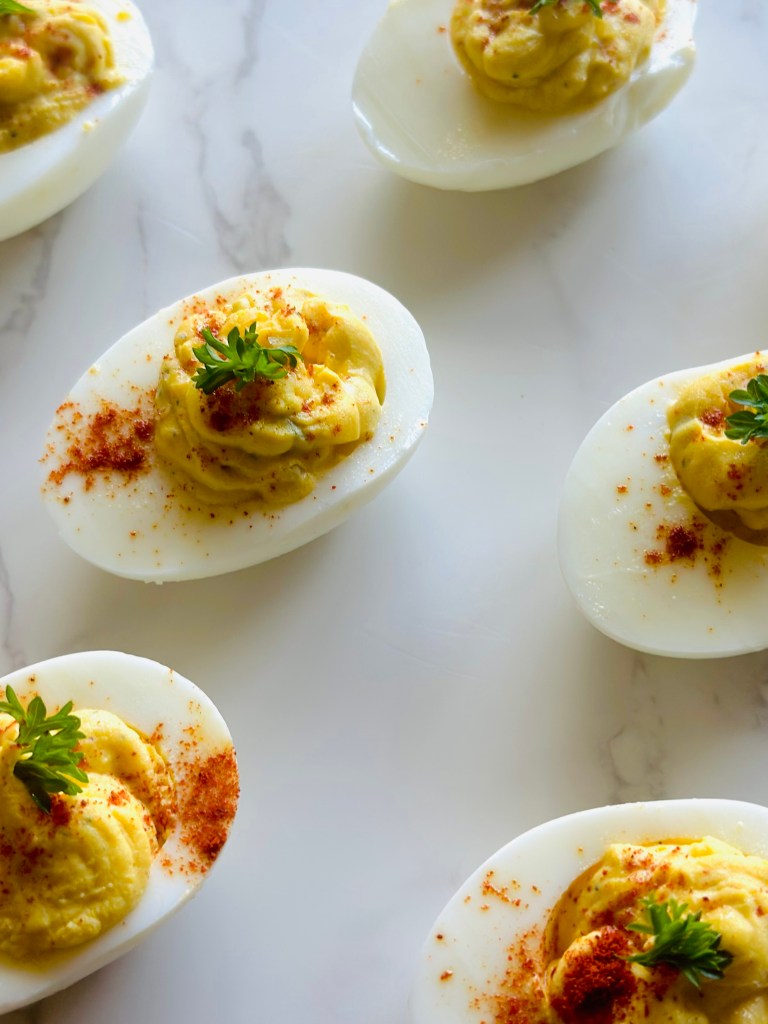 A photo of deviled eggs garnished with paprika and parsley