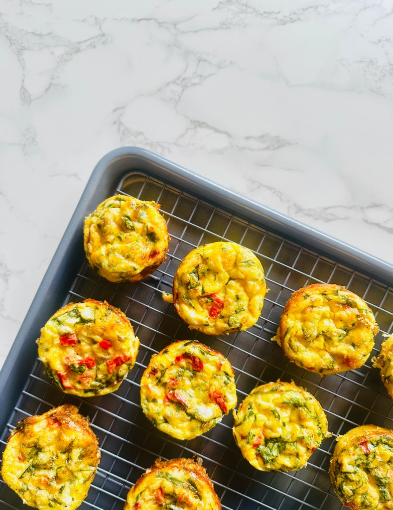 A baking sheet fitted with a wire rack that is filled with homemade cottage cheese egg bites