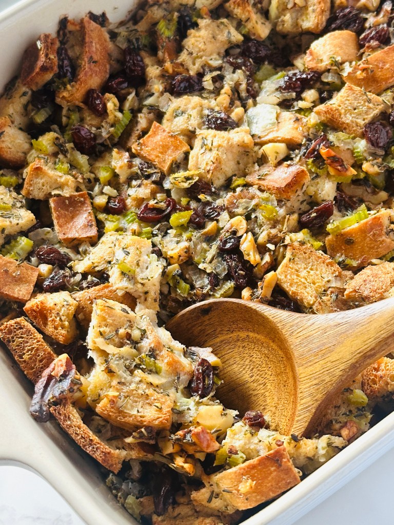 A photo of traditional Thanksgiving stuffing being served out of a baking dish